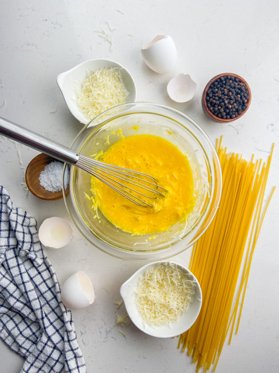 Eggs and cheese whisked together in glass bowl. 