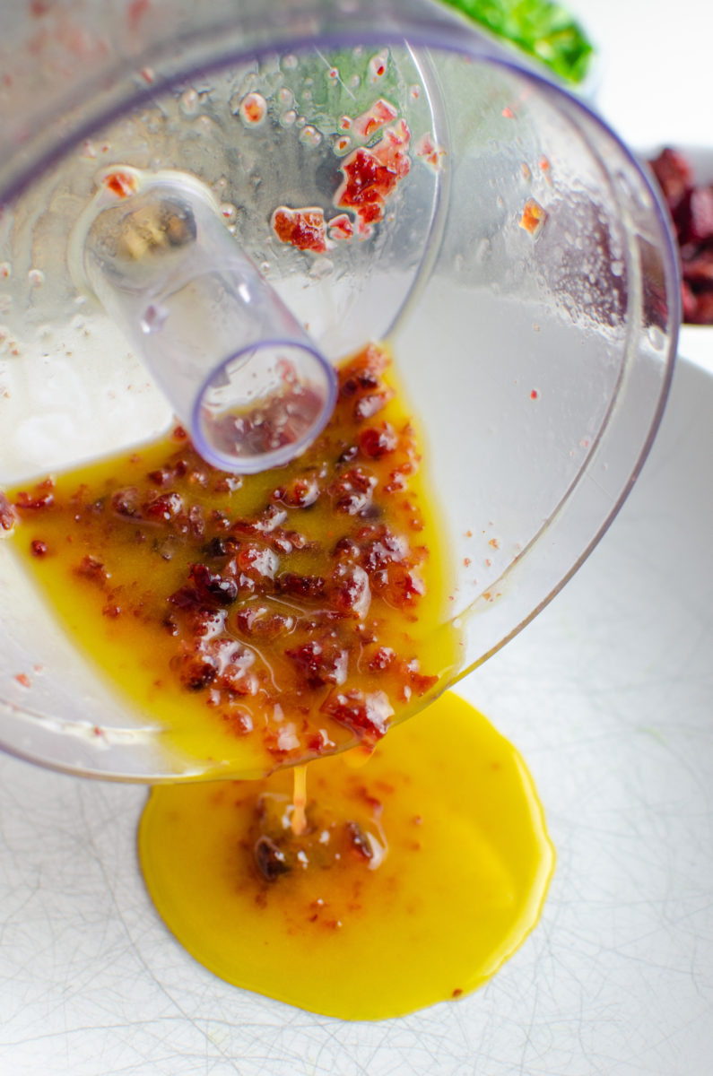 Pouring dressing into a bowl.