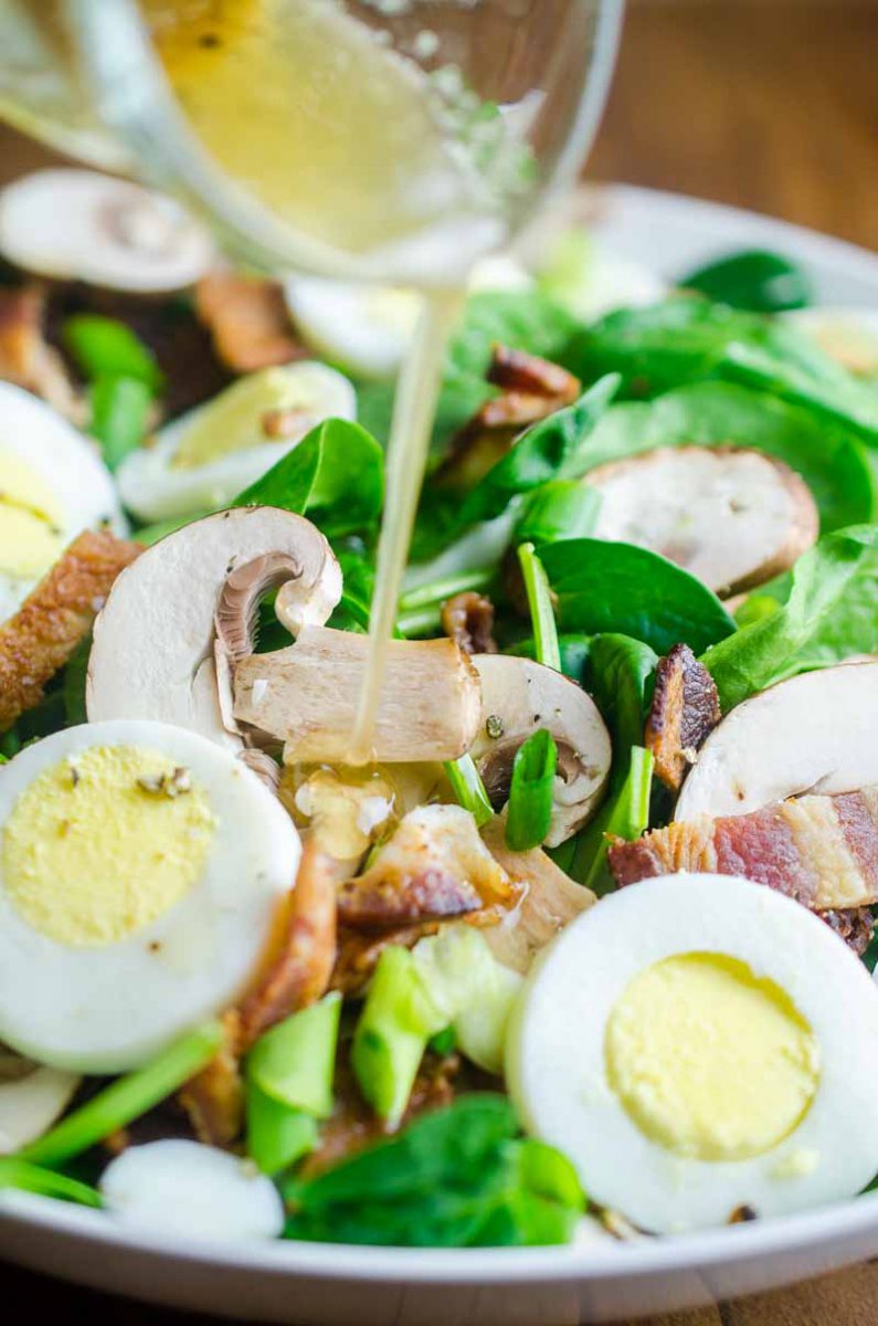 Spinach Salad with Bacon Dressing is a classic for a reason. Fresh spinach tossed with mushrooms, crispy bacon, hard boiled eggs and tossed with a warm bacon dressing. 