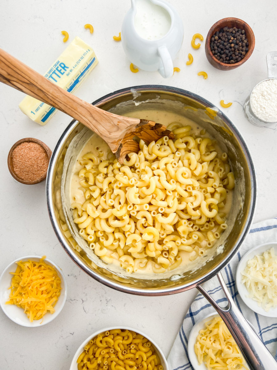 Adding noodles to cheese sauce. 