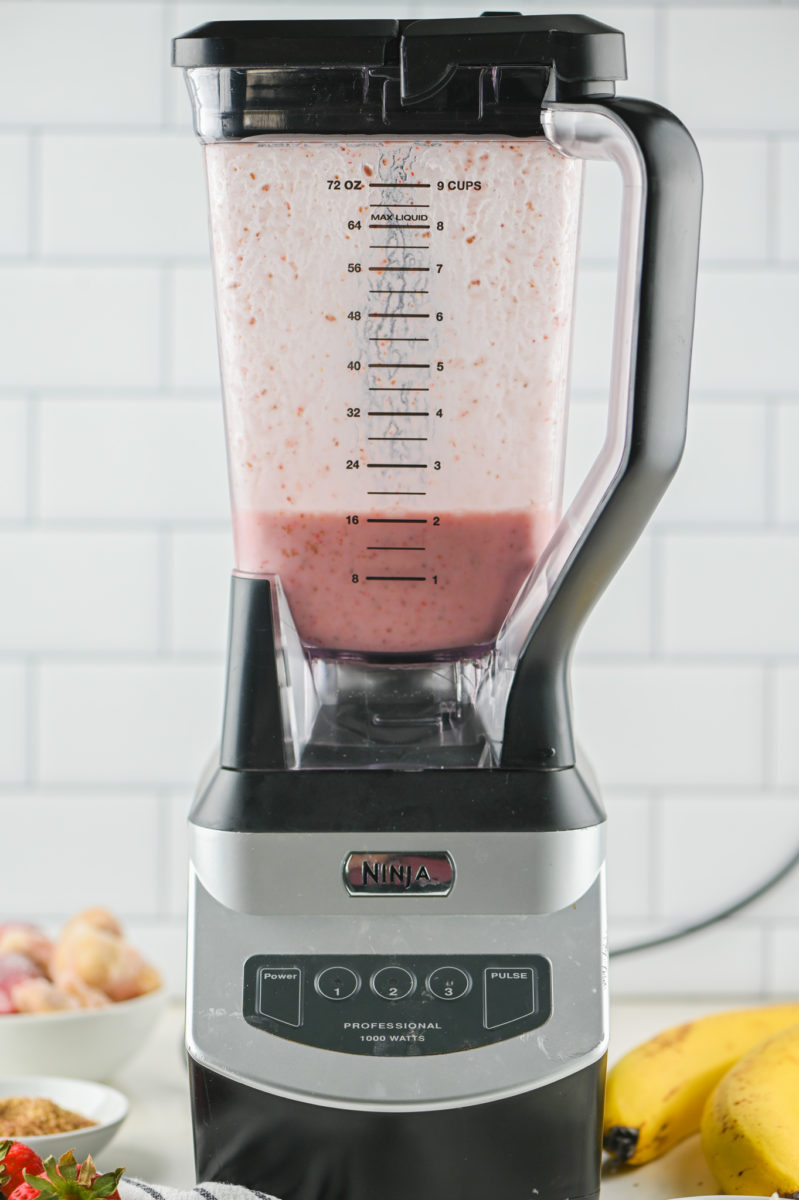 A blender with strawberry banana smoothie inside. 