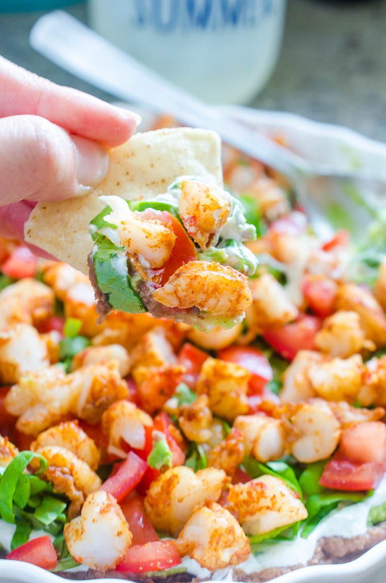 Everyone one loves a good shrimp taco. Everyone loves a good taco dip. I've put them together in this Taco Shrimp Dip with black beans, lettuce, cilantro sour cream, tomatoes and spicy shrimp.