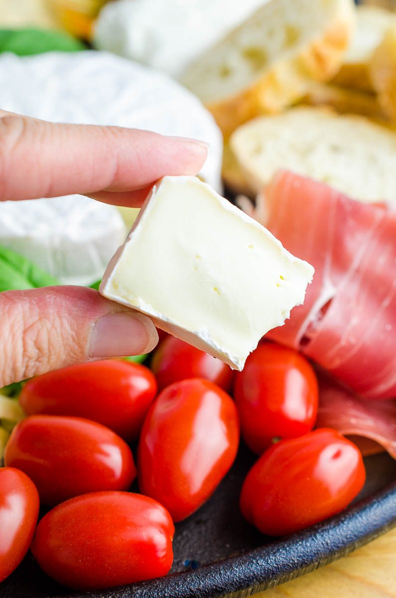 This Summer Charcuterie Board is loaded with 3 different kinds of cheese, meat, olives, tomatoes, crackers and sweet honey. It's perfect for all of your snacking this summer. 