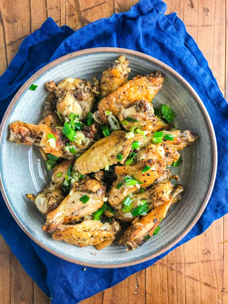 Baked Salt and Pepper Chicken wings are baked until crispy and tossed in a mixture of sesame oil, jalapeños, garlic and green onions.