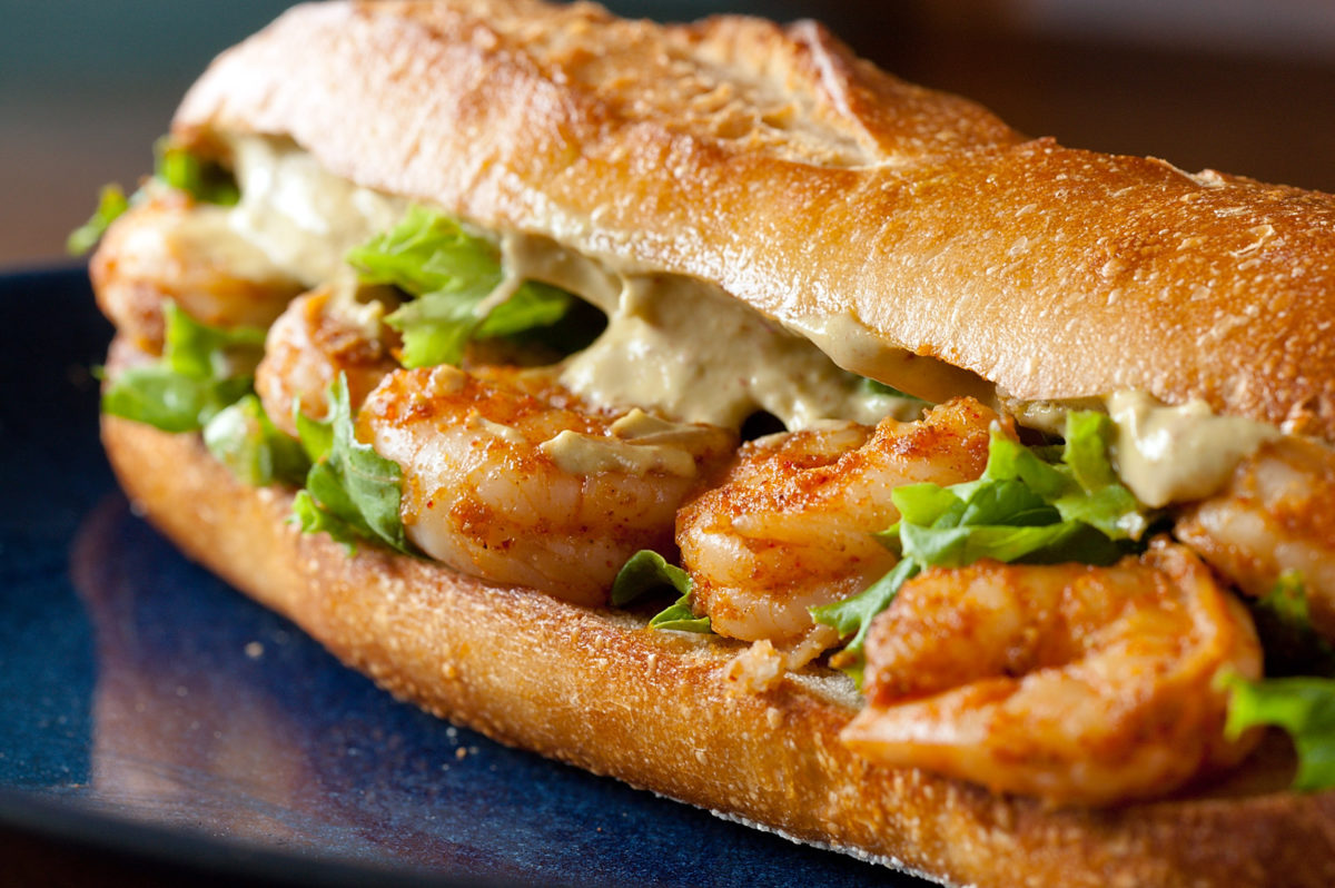 Spicy shrimp sandwich on blue plate.